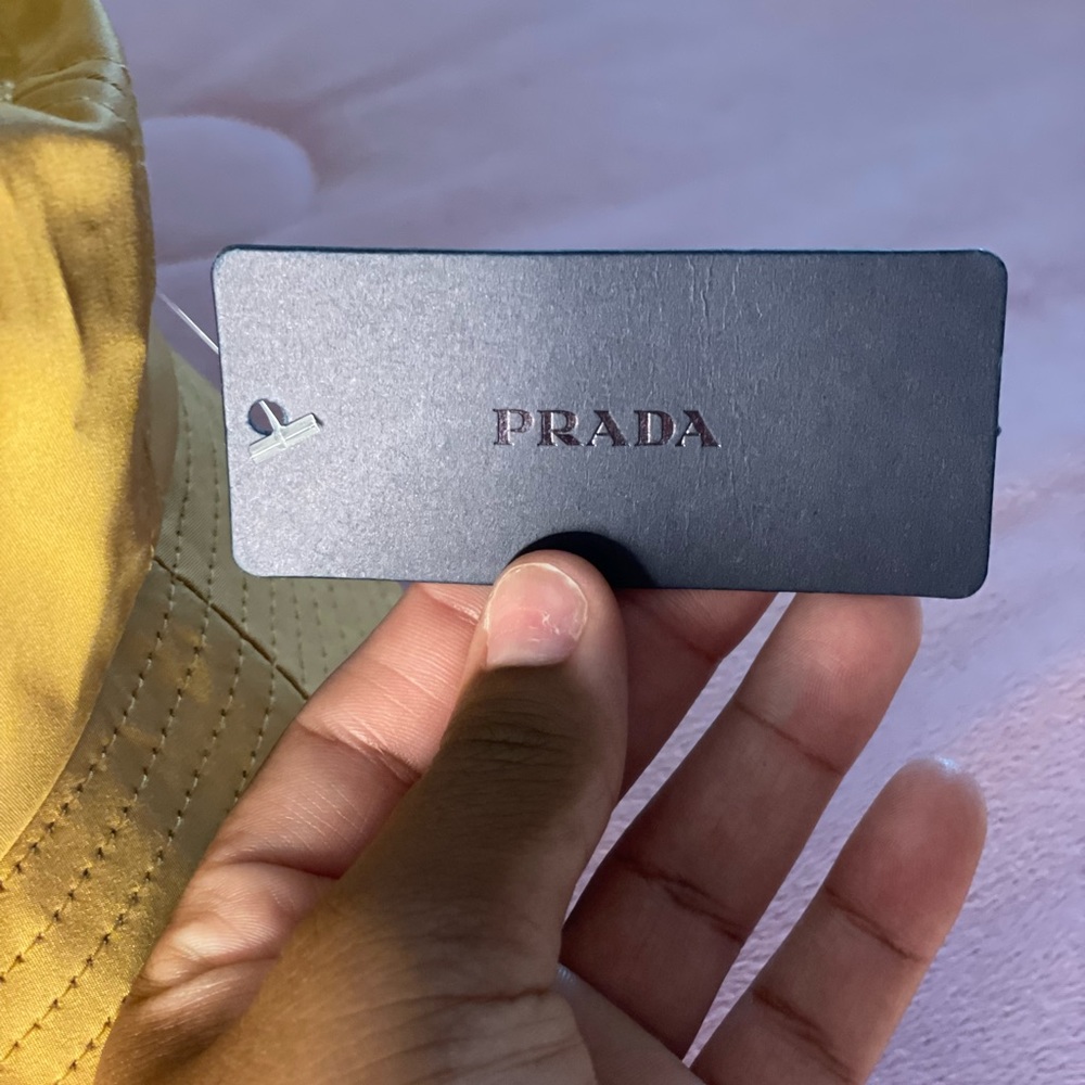 mustard colored prada bucket hat.